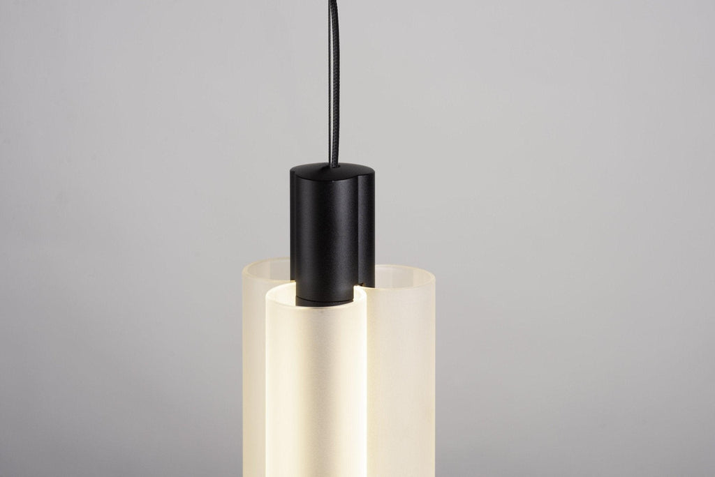 Close view of the black cap and cable at the top of this Clérachic pendant, with the frosted white lobes below it.