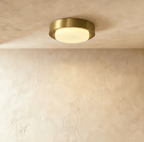 Clérachic larger round flush ceiling light with a deep brushed brass rim and a softly glowing frosted glass cover.