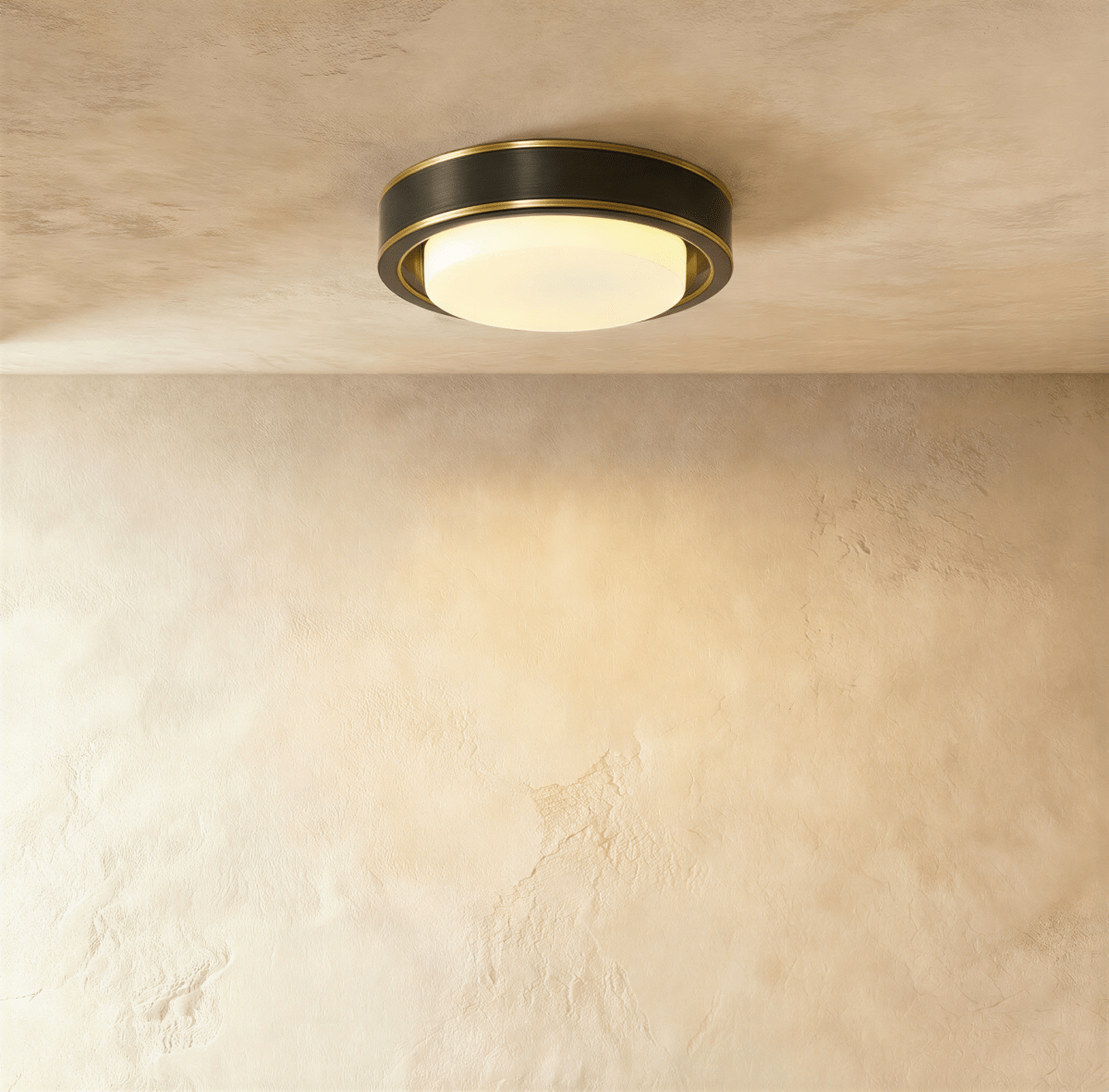 Clérachic larger round flush ceiling light in a dark black finish with fine brass edging and a glowing frosted glass cover.