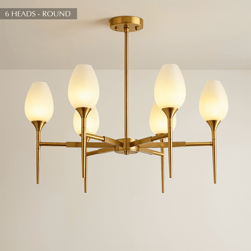 Clérachic six-arm brass chandelier with frosted tulip shades on slim arms, hung from a brass stem and round ceiling plate.