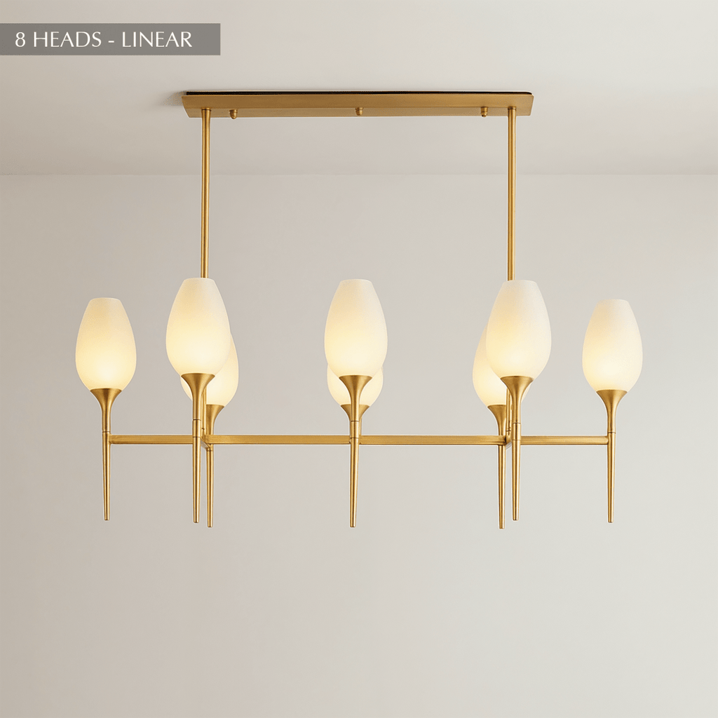 Clérachic linear brass chandelier with eight frosted tulip shades on a long rod frame, hung from a rectangular ceiling plate.