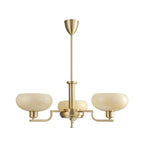 Three-head gold Clérachic chandelier on a white backdrop, wide pale glass domes on brass arms with a tall stem.