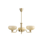 Smaller three-head gold Clérachic chandelier on white, three pale beige glass domes on slim brass arms.