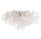 This Clérachic ceiling light in its silver finish sits on a white background, with clear glass discs cascading from its branches.