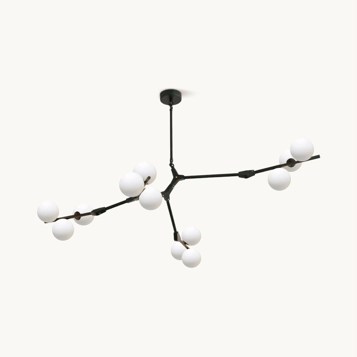 Branching black chandelier from Clérachic with frosted white glass globes on slim arms, hung from a round ceiling plate on a white backdrop.