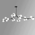 Black Clérachic chandelier with frosted globes in several clusters along its branches, unlit, on a grey gradient background.