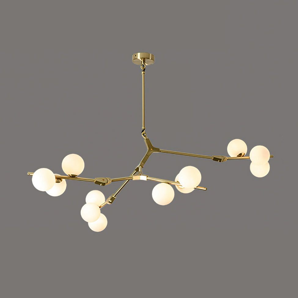 Gold and white three-armed chandelier with lit globes on thin brass branches, hung from a small gold canopy on dark grey; Clérachic.