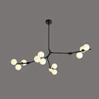 Black Clérachic chandelier lit on a dark grey background, three branches reaching out with frosted globes at their ends.