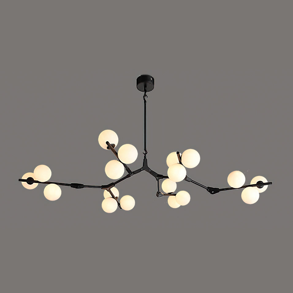 Black branching chandelier with warm globes glowing in clusters, hung from a round black ceiling plate on a dark grey backdrop; Clérachic.