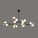 Black branching chandelier with warm globes glowing in clusters, hung from a round black ceiling plate on a dark grey backdrop; Clérachic.