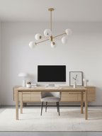 Gold-finish Clérachic chandelier with six white globes above a light oak desk with a monitor, in a calm, pale home office.