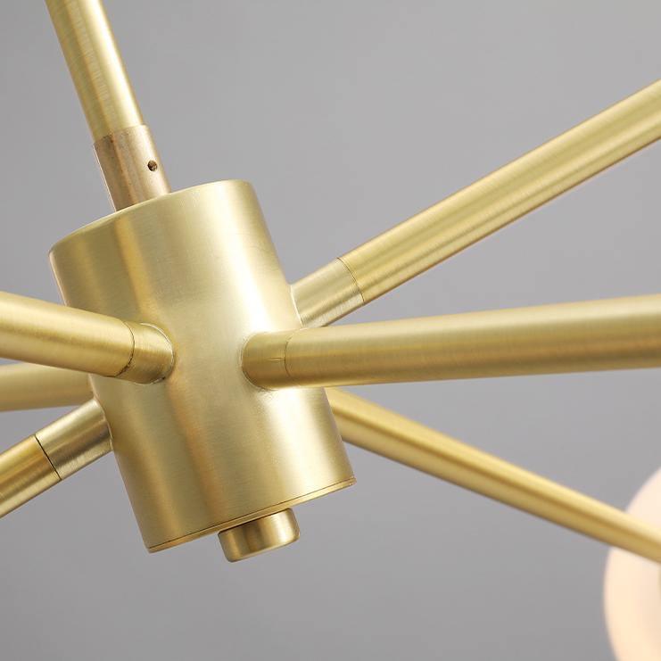 Close view of the brushed gold central hub on this Clérachic chandelier, where several slim arms join the main rod.