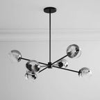 Black six-globe Clérachic chandelier with mirrored smoked shades, seen from below with a white cornice behind it.