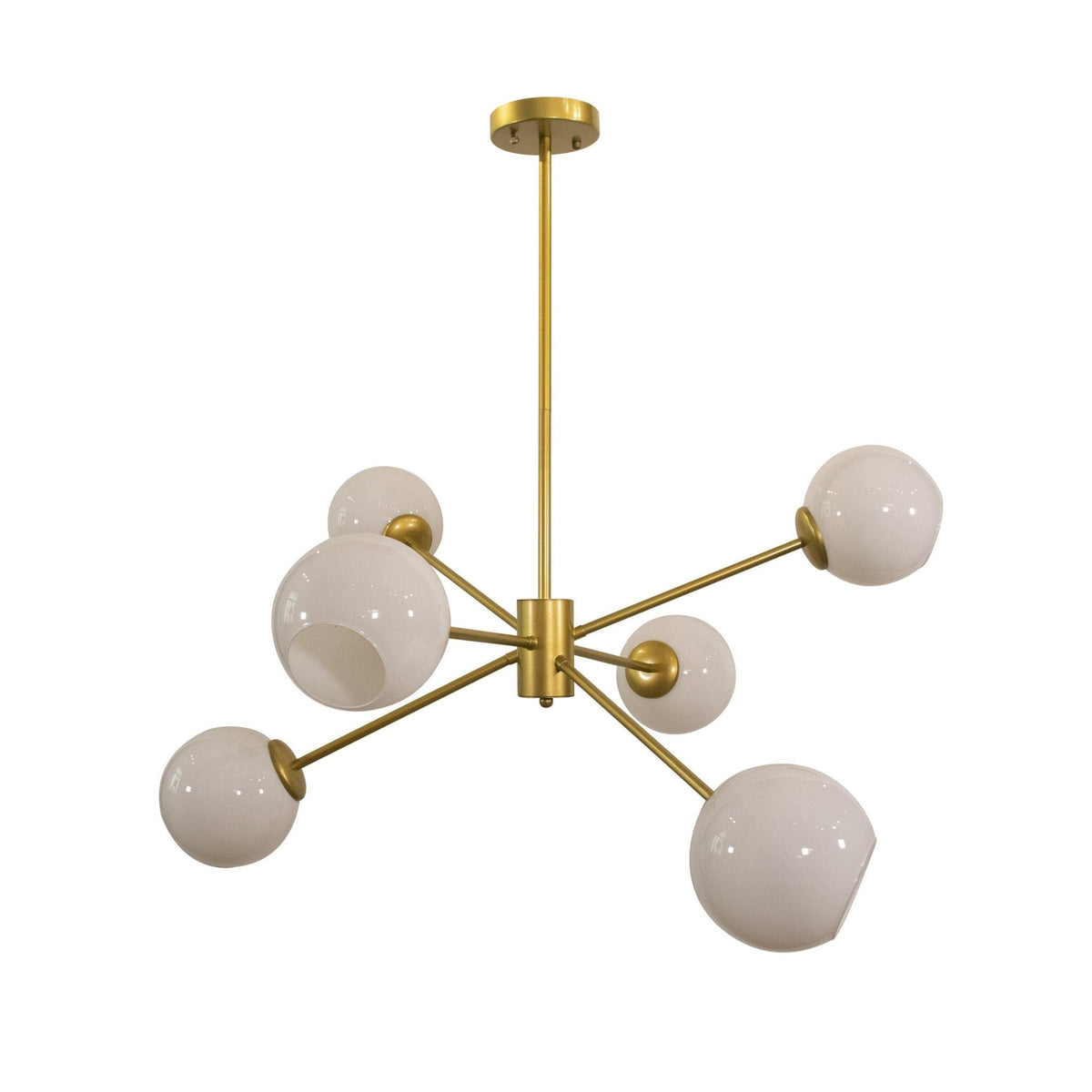 Six-light gold chandelier from Clérachic with opal white globes on slim arms, shown from a low angle on white.