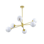 Gold chandelier from Clérachic with six white globes, one with a bulb showing, seen from the side on a white background.
