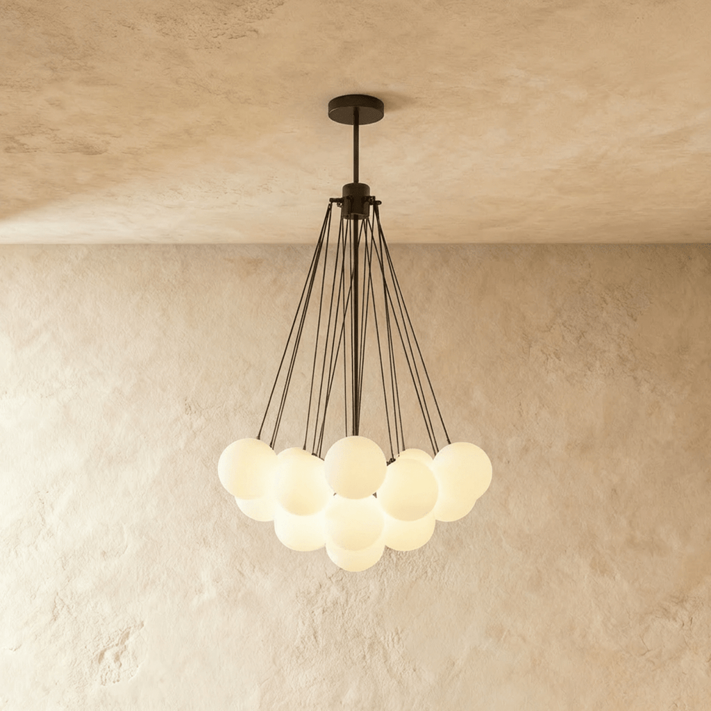 Clérachic cluster chandelier with frosted glass spheres hanging from slim black rods and a black canopy, glowing softly.