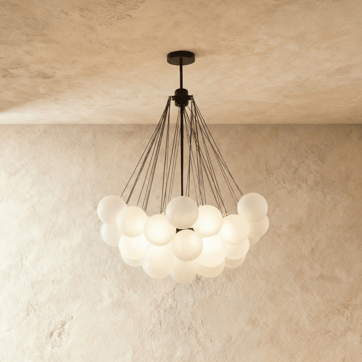 Clérachic larger cluster chandelier with many frosted glass spheres hung from black rods and a black canopy, glowing.