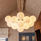 Close view of a Clérachic gold-toned cluster chandelier, showing smooth frosted glass spheres and fine rods meeting at the stem.
