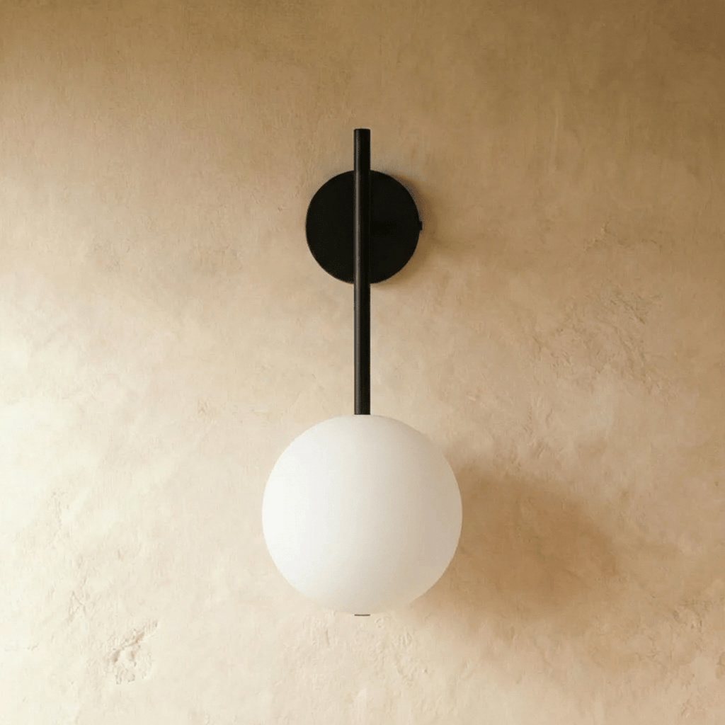 Clérachic wall lamp in black, switched off, showing the plain white sphere and the round wall plate at the top of the rod.