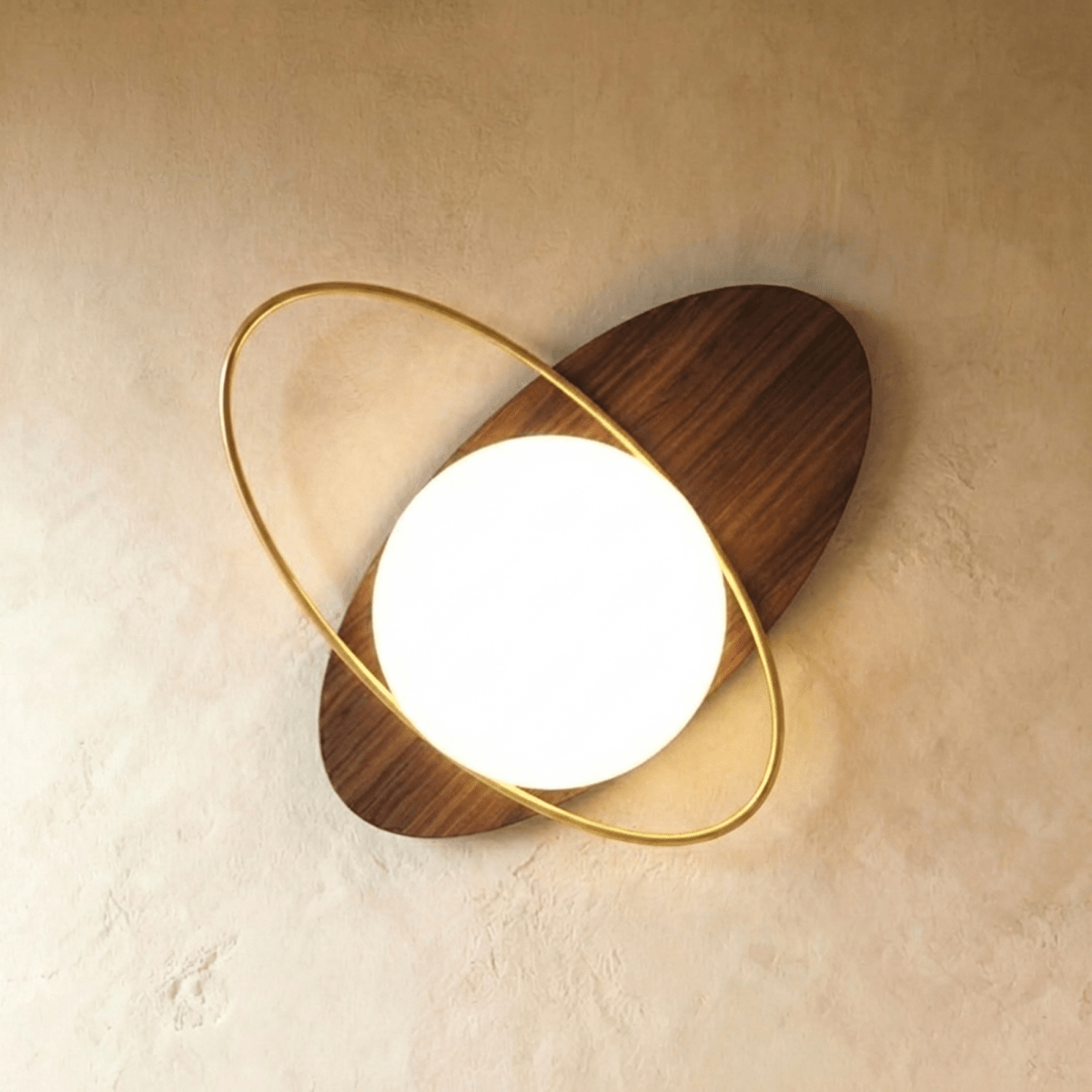 Clérachic wall lamp with a walnut-finished elliptical disc showing its wood grain, tilted and threaded by a gold ring around the lit sphere.
