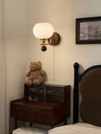 Ribbed glass Clérachic wall light at the same bedside corner, with a teddy bear on the cabinet and a framed painting at the edge.