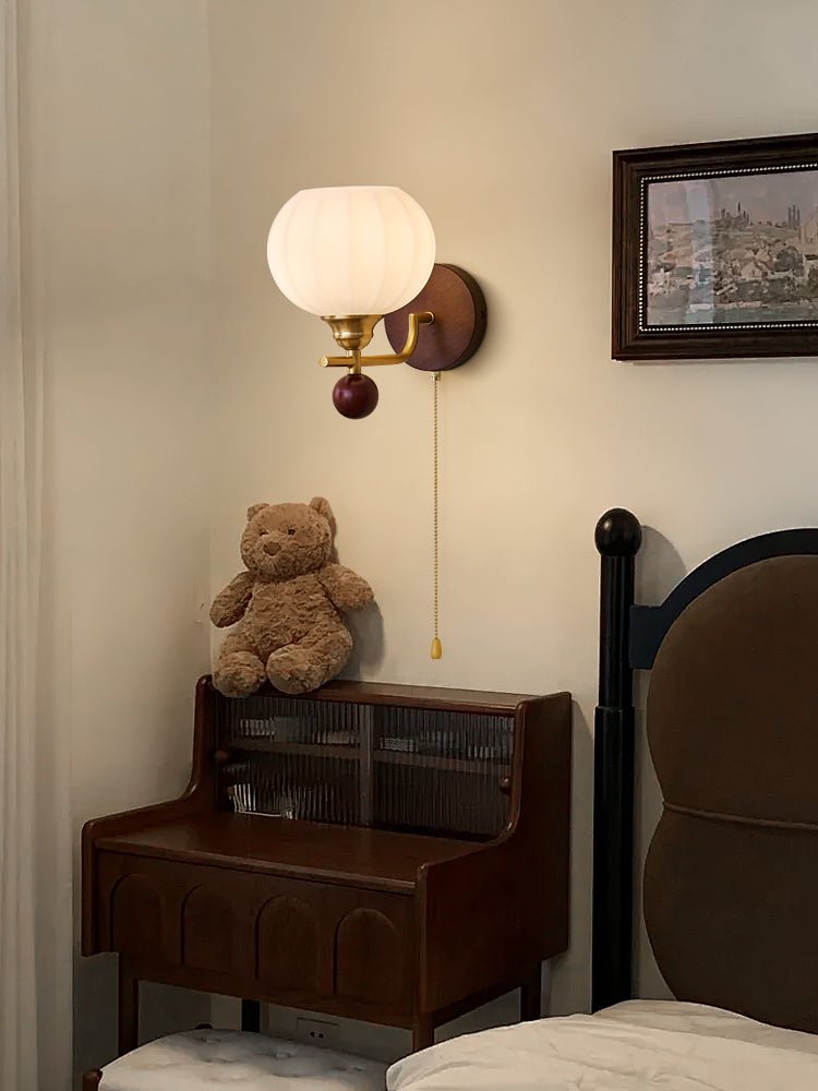 Ribbed glass Clérachic wall light at the same bedside corner, with a teddy bear on the cabinet and a framed painting at the edge.