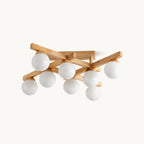 Eight frosted white globes on crossed wood arms, this Clérachic flush-mount ceiling light shown on a plain white backdrop.