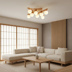 Wood-frame Clérachic ceiling light with frosted globes, lit above a low coffee table and cream corner sofa beside a timber-framed sliding screen.