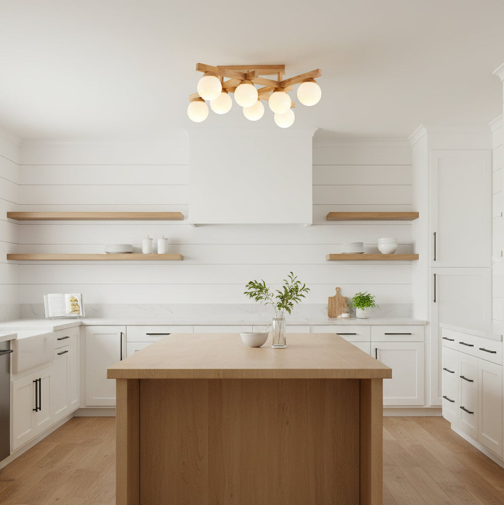 Wood-and-glass Clérachic flush-mount light hanging above a wood-topped kitchen island, with white cabinets and open timber shelves behind.