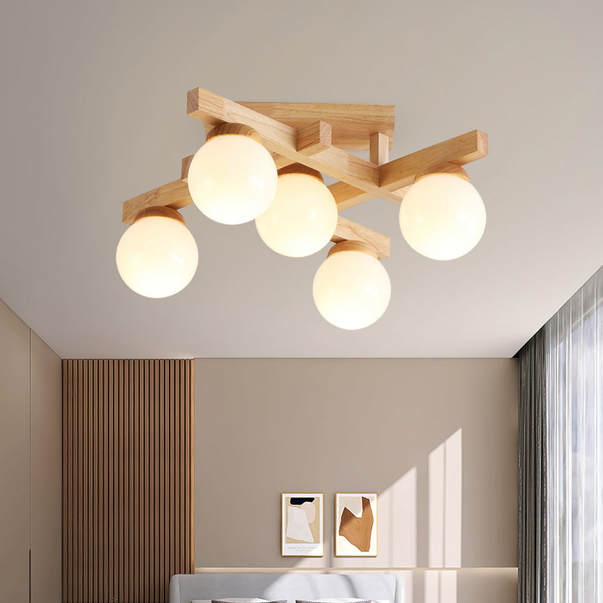 Looking up at five lit frosted globes on crossed wood arms, a Clérachic ceiling light with a panelled wall and small artworks below.