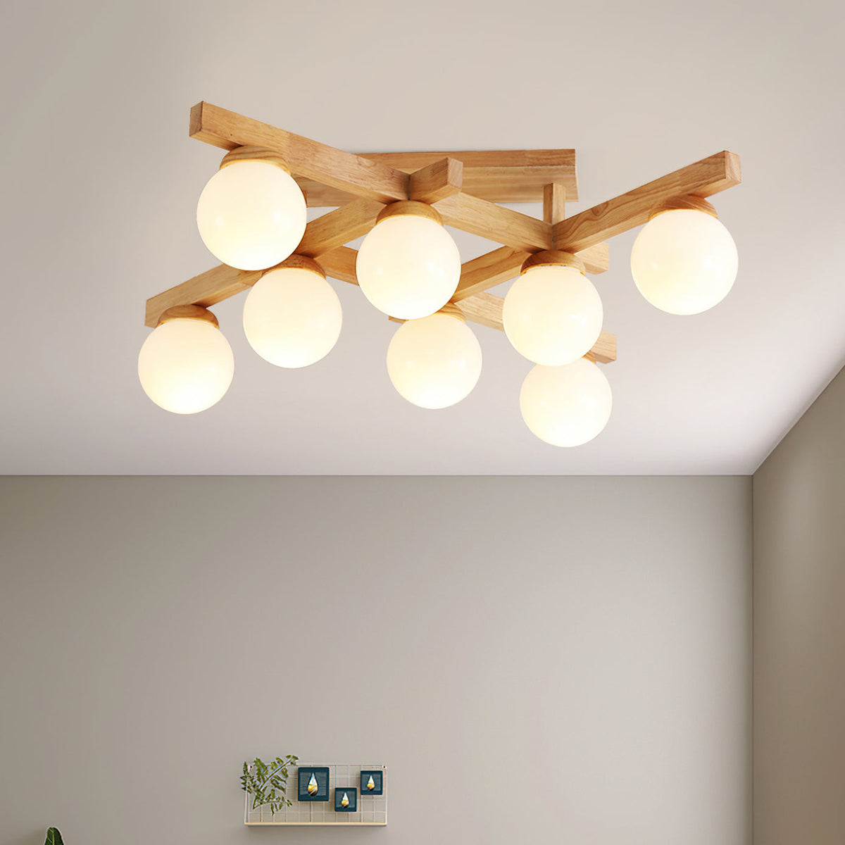 Eight frosted globes glowing on a wood cross frame, this Clérachic ceiling light viewed from below against a pale ceiling and plain wall.