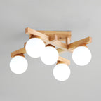 Close angle on a five-globe Clérachic ceiling light, showing the wood backplate with its screw and the frosted globes against a grey ceiling.