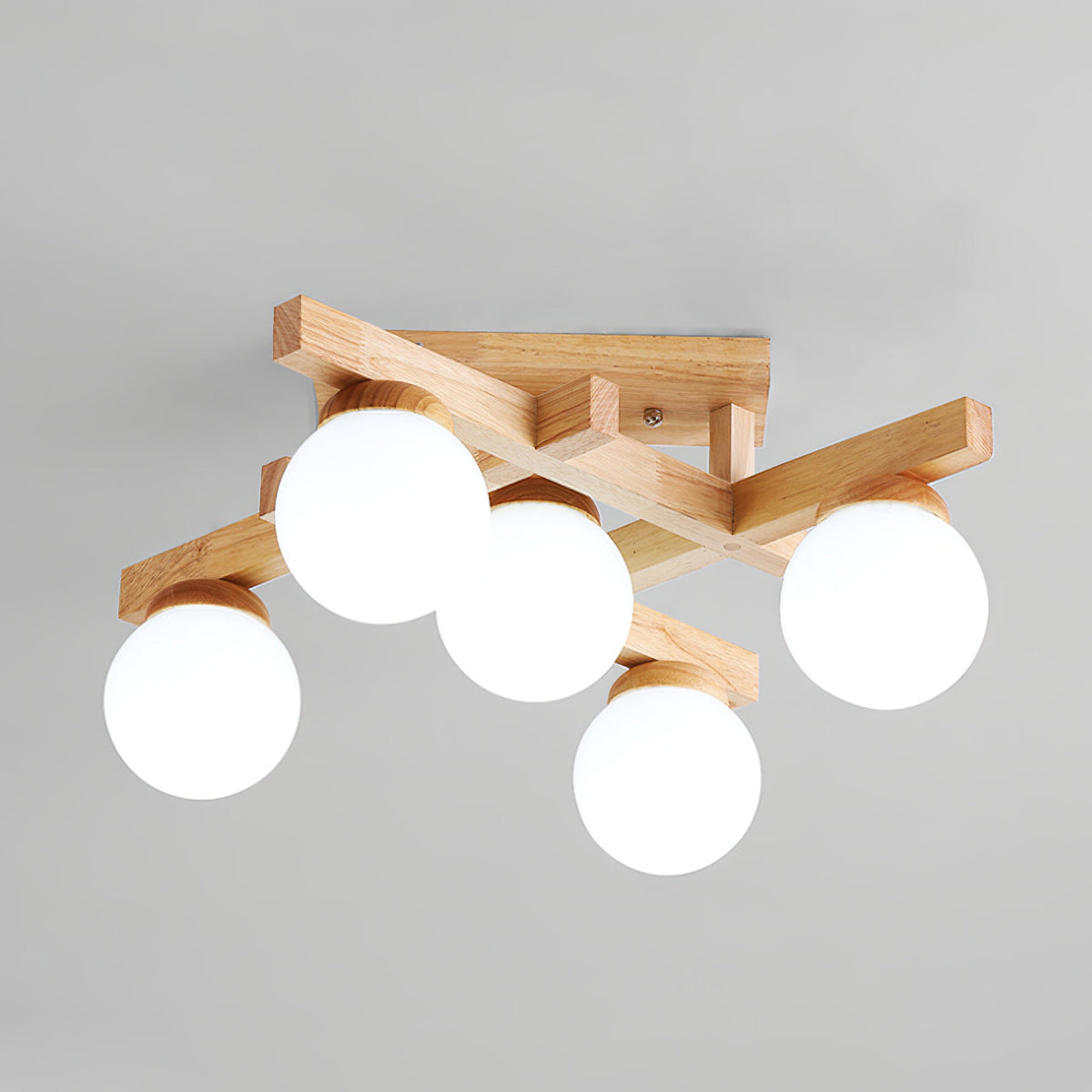 Close angle on a five-globe Clérachic ceiling light, showing the wood backplate with its screw and the frosted globes against a grey ceiling.