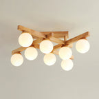 Eight frosted globes lit under a crossed wood frame, this Clérachic flush-mount light photographed against a soft grey-beige ceiling.