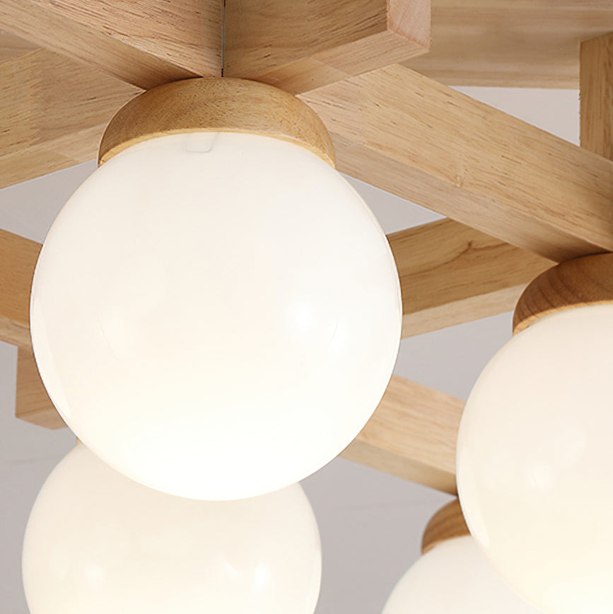 Close view of a large frosted globe seated in its wood cap on the crossed wood arms of this Clérachic ceiling light.