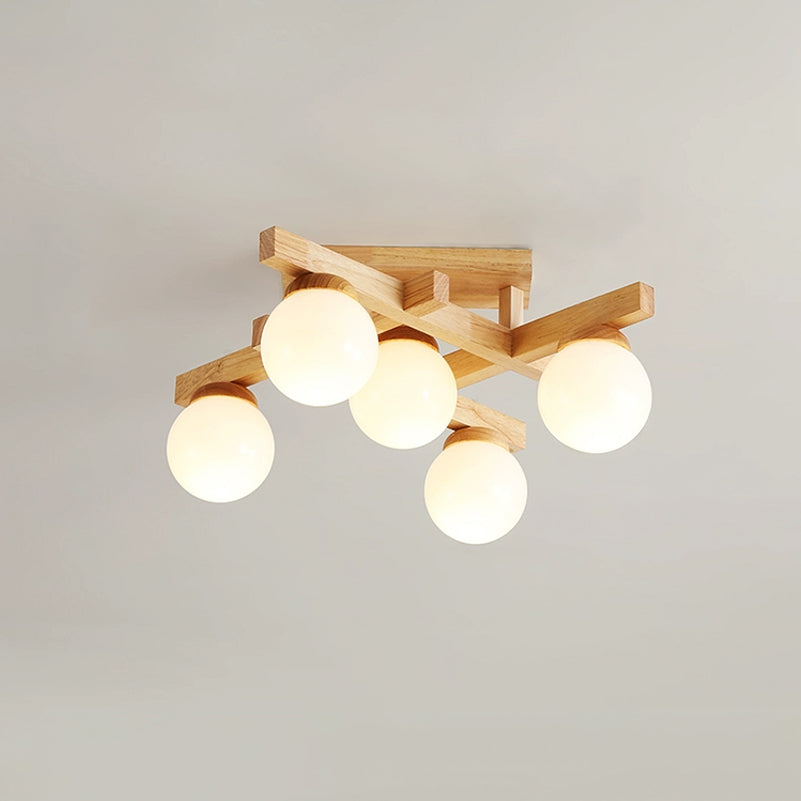 Five lit frosted globes on a compact wood cross frame, this Clérachic ceiling light seen from below against a pale grey ceiling.