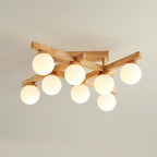 This Clérachic ceiling light with eight warm-lit frosted globes under a crossed wood frame, against a pale ceiling with a soft shadow.