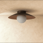 Clérachic flush ceiling light switched off, with a broad dark brown disc shade and a pale frosted globe against a plaster ceiling.