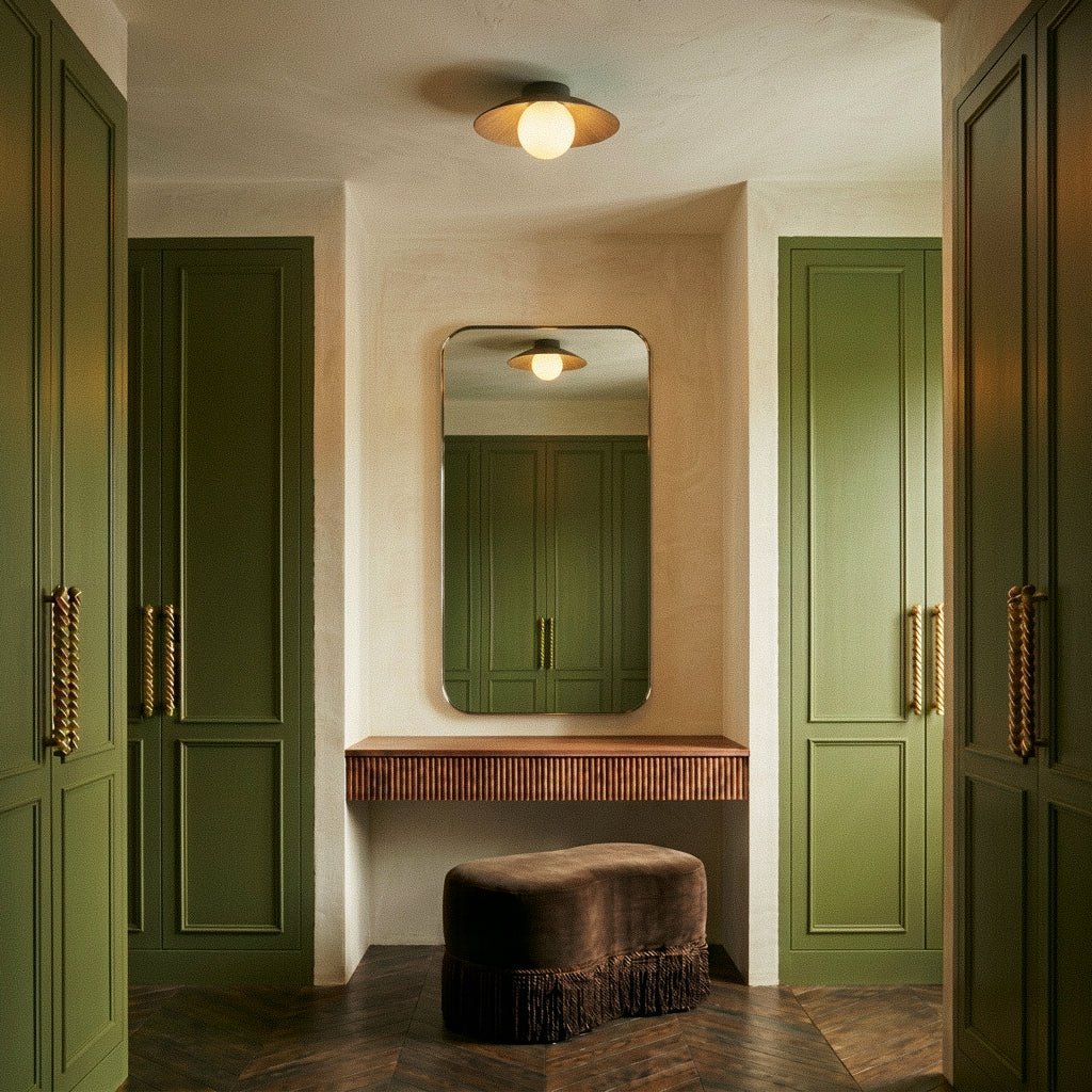 Clérachic wood-toned disc ceiling light with a glowing globe in a dressing area of olive panelled doors and an arched mirror.