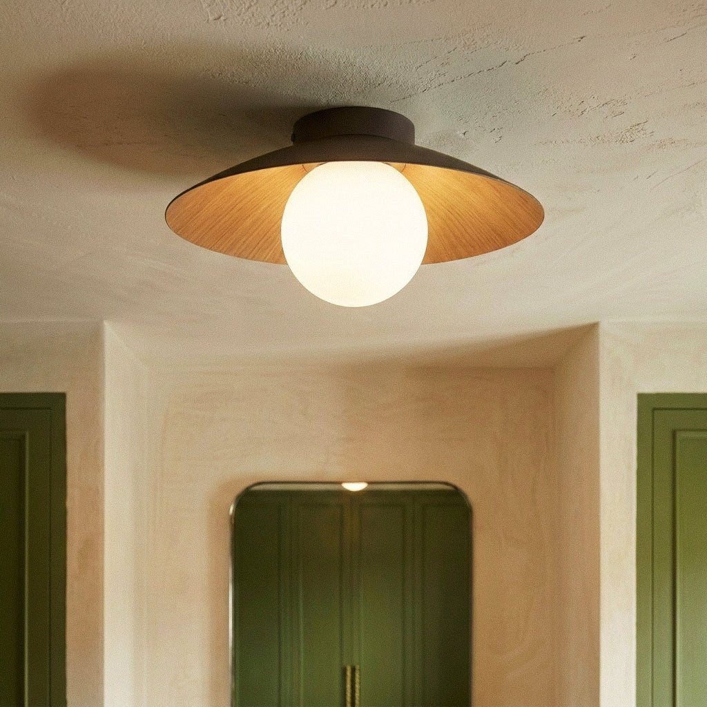 Clérachic flush ceiling light with a dark brown disc shade, wood underside and opal globe, in a hall with olive green doors.