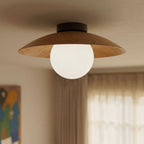 Close view from below of the Clérachic ceiling light's wood-grain disc shade and round opal glass globe near sheer curtains.