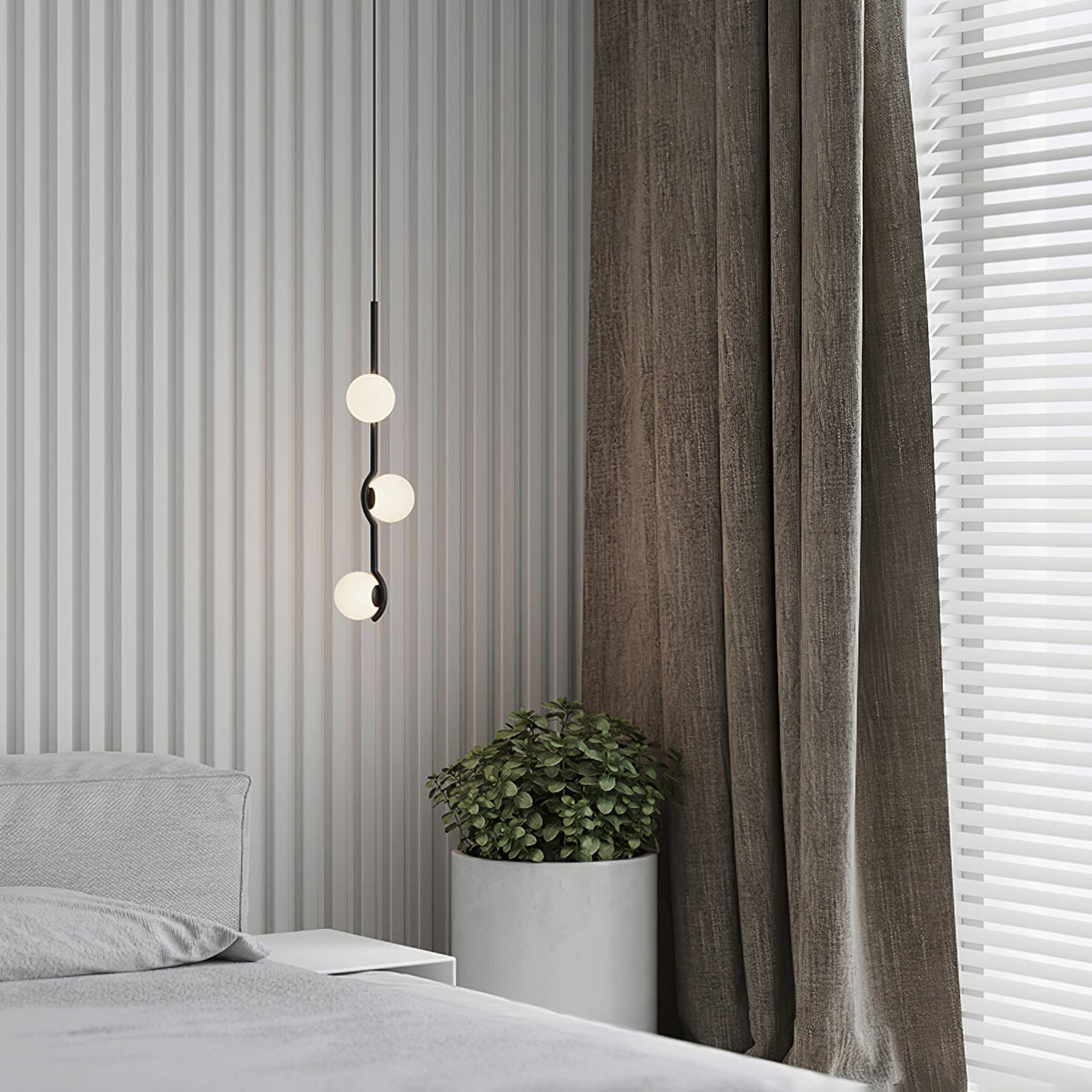 A Clérachic pendant with three globes on a thin black line hangs beside curtains, above a grey bed and a plant.