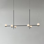 A long Clérachic chandelier in black on two rods, with six frosted globes along its arms, on a plain grey wall.