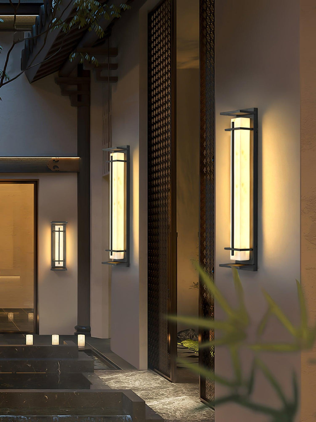 Three Clérachic wall lights of different heights lit along an entrance wall with a dark timber screen and stone steps.