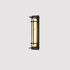 Slim dark-framed wall light with a softly glowing pale shade, on a plain light grey backdrop; this Clérachic design.
