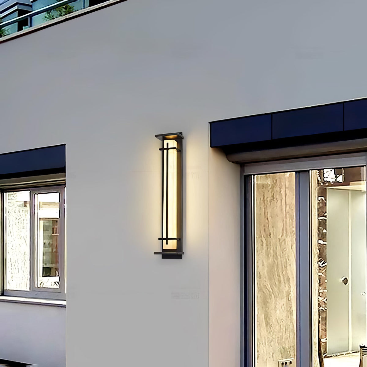 A single lit Clérachic wall light on a pale rendered wall beside a window and a sliding glass door.