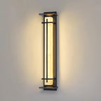 Close view of a lit Clérachic wall light with a wide warm glow spreading across a beige wall.