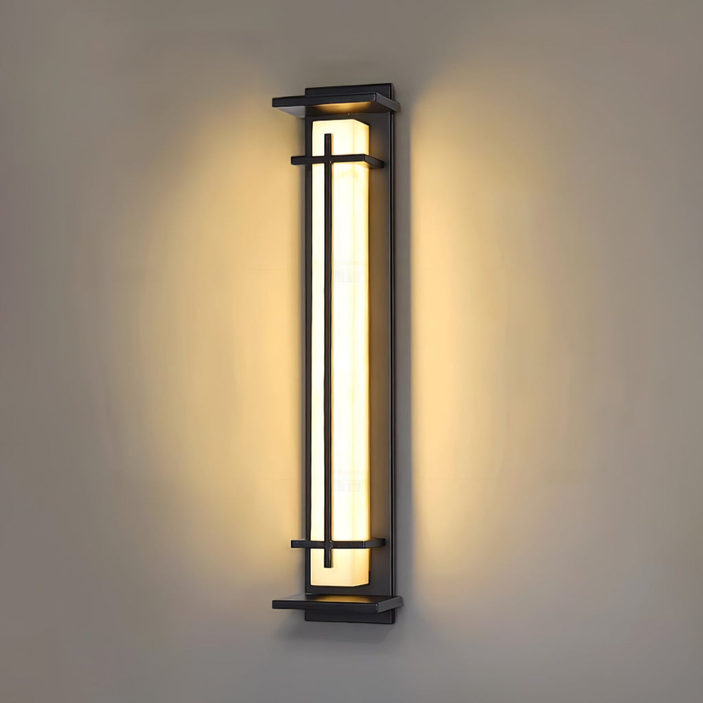 A Clérachic wall light shining warm on a taupe wall, a soft halo of light around the dark frame and shade.