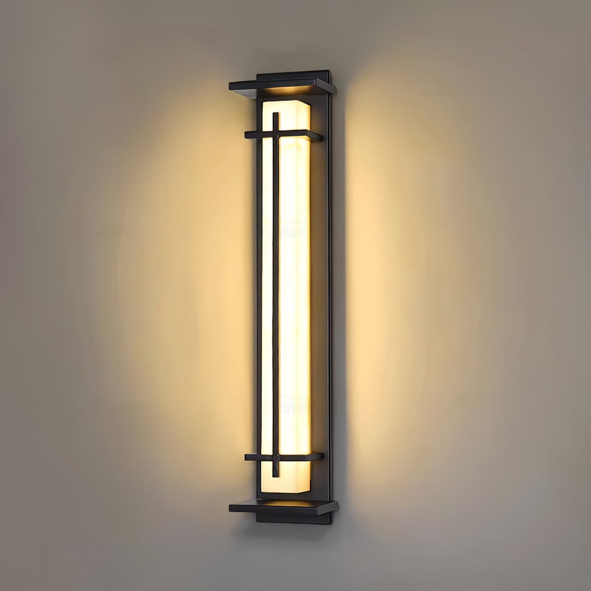 A Clérachic wall light shining warm on a taupe wall, a soft halo of light around the dark frame and shade.
