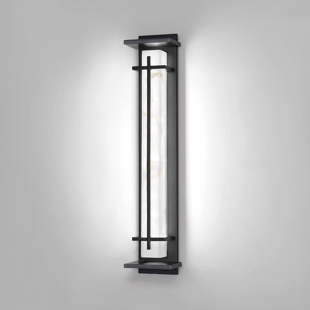 Wall light switched to a cool white, the pale veined shade bright inside the dark frame, on a grey wall; from Clérachic.